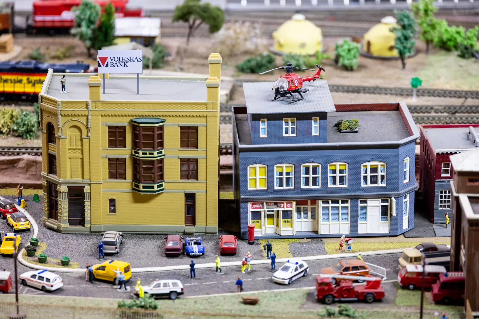 A close-up photograph of a detailed miniature library diorama with tiny books and shelves.